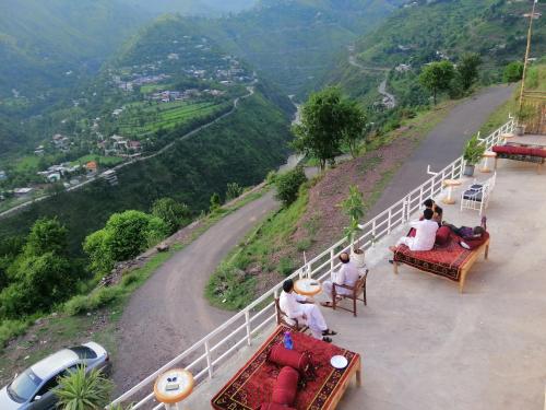 a group of people sitting on chairs on the side of a road at Sky resort ajk patikka in Muzaffarabad