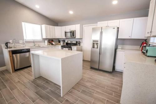 a kitchen with white cabinets and a stainless steel refrigerator at Spacious Stylish and Convenient in Las Vegas