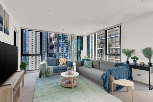 a living room with a couch and a tv at Zen Grand 3 Bedroom Residences 120m2 with up to 7 Separate Beds in Melbourne