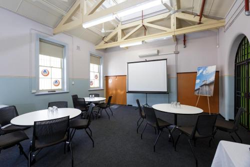 a classroom with tables and chairs and a whiteboard at YHA Fremantle Prison in Fremantle