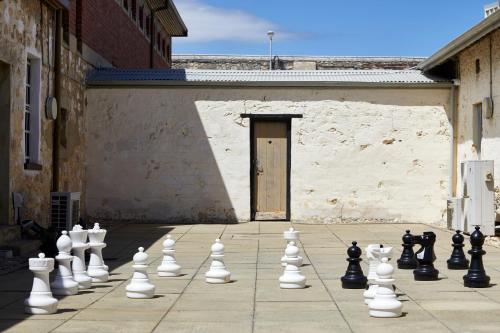 a giant chess set on a sidewalk in front of a building at YHA Fremantle Prison in Fremantle