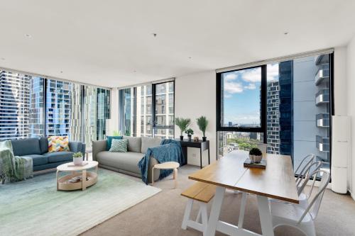 a living room with a couch and a table at Nook Melbourne Apartments Zen in Melbourne