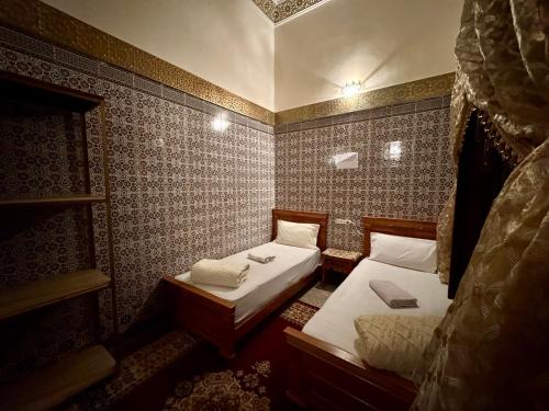 a small room with two beds in it at Dar Yassine in Rabat