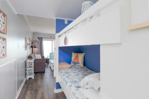 a bedroom with a bunk bed with a blue wall at Oceanfront Bliss at Wave Raider -Perfect Getaway in North Topsail Beach