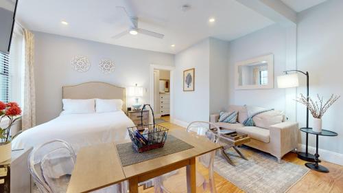 a bedroom with a bed and a table and a couch at Renovated, Spacious Studio, Near Bc, Bu, Porch in Boston