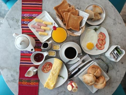 Una mesa cubierta con platos de desayuno y café. en Hotel Vila Santa, en Lima