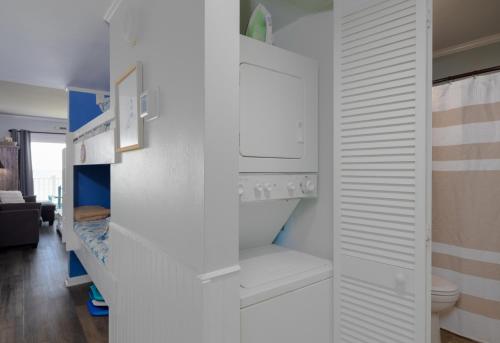 a bathroom with white cabinets and a toilet at Oceanfront Bliss at Wave Raider -Perfect Getaway in North Topsail Beach