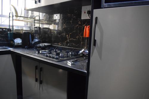 a kitchen with a stove and a refrigerator at Amangee Luxury Apartments in Jimeta
