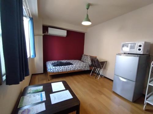 a living room with a couch and a refrigerator at 下町の穴場 キッチン完備 長期滞在に最適なお部屋 Rapyuta monthly apartment in Kyoto