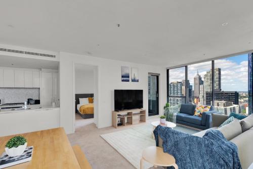 a living room with a couch and a tv at Nook Melbourne Apartments Zen in Melbourne