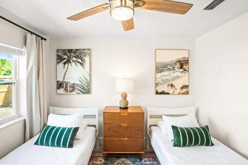 ウェストパームビーチにあるEast Coast Oasis- Pool & Park Your Boat, Sleeps 8のベッド2台と天井ファン付きの寝室