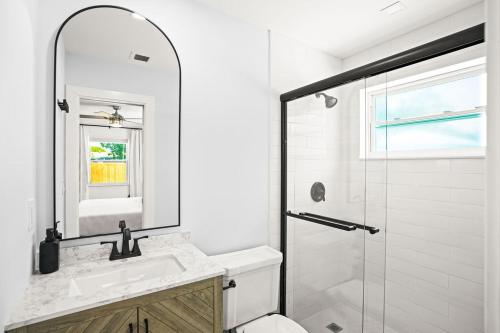 ウェストパームビーチにあるEast Coast Oasis- Pool & Park Your Boat, Sleeps 8の洗面台とシャワー付きの白いバスルーム