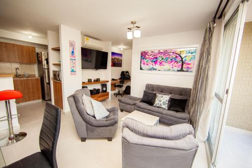 a living room with a couch and chairs and a table at Apartamentos en el Sur de Cali, parqueadero propio, piscina, wifi in Cali