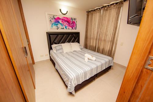 a bedroom with a bed with a stuffed animal on it at Apartamentos en el Sur de Cali, parqueadero propio, piscina, wifi in Cali