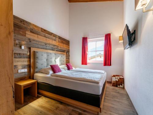 Un dormitorio con una cama con una pared de madera. en Tauernsuites Mitterwirt TOP 322, en Piesendorf