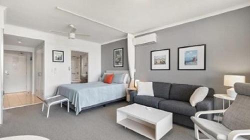 a living room with a bed and a couch at Panorama Daze Ettalong Beach in Ettalong Beach