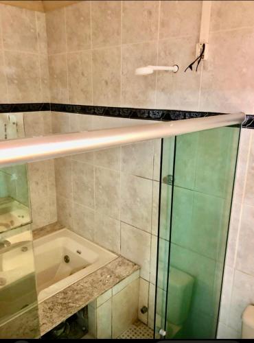 a bathroom with a glass shower and a tub at Pousada Recanto do Sabiá in Barcarena