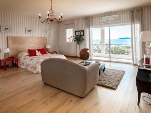 La NartelleにあるLa Meréveilのベッドとソファとテーブルのある寝室