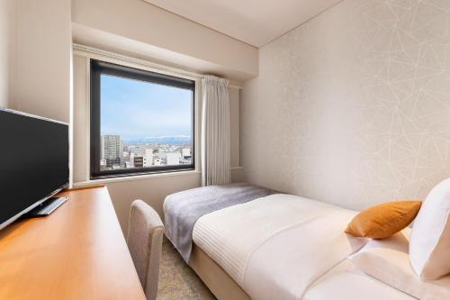 Postel nebo postele na pokoji v ubytování Art Hotel Niigata Station