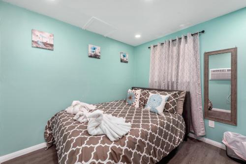 a bedroom with a bed with blue walls and a mirror at Tiny & Chic Heights Hideaway with Free Parking in Houston