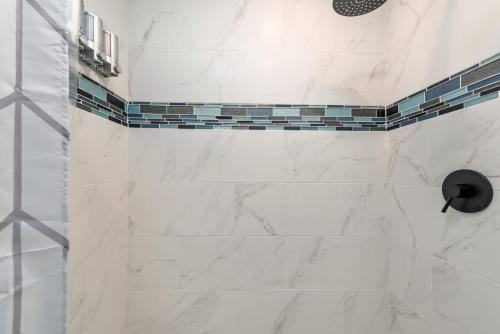 a bathroom with a shower with white marble tiles at Tiny & Chic Heights Hideaway with Free Parking in Houston