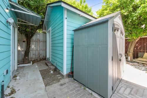 a blue shed next to a fence at Tiny & Chic Heights Hideaway with Free Parking in Houston