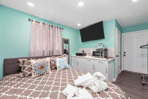 a bedroom with blue walls and a bed and a kitchen at Tiny & Chic Heights Hideaway with Free Parking in Houston