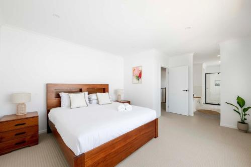 a bedroom with a large bed with white sheets at Torquay Beach Getaway in Torquay