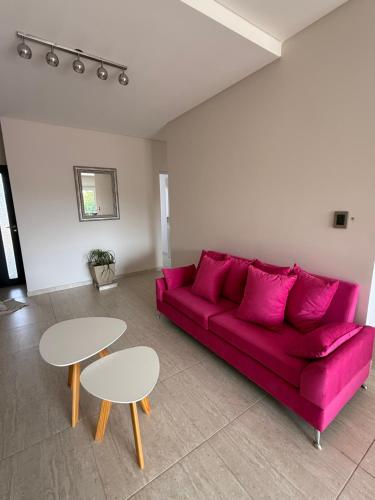 een woonkamer met een rode bank en 2 tafels bij Departamento Luz in Plottier