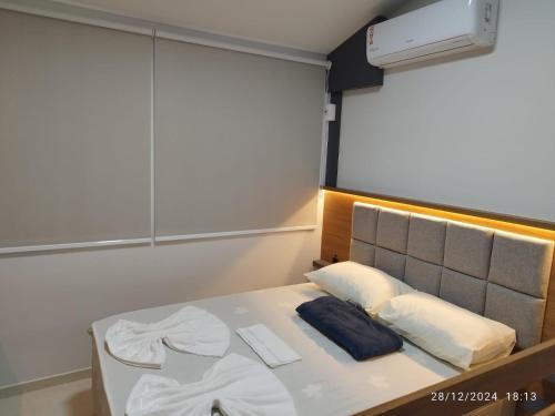 a bed in a small room with avertisementatronatronstrationstrationstration at Loft 01 in Tubarão