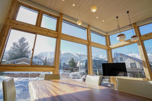 a large dining room with a table and large windows at KYLA by Hakuba White Fox, Echoland Luxe w Mountain Views in Hakuba