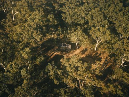 an aerial view of a cabin in the middle of a forest at Remote Off-Grid Cabin Hidden in the Bush - Yen in Mangrove Mountain
