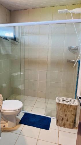 a bathroom with a toilet and a glass shower at Todo Azul do Mar in Taíba