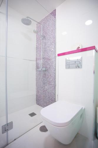 a white bathroom with a toilet and a shower at Modern Designer Apartment Taurito in Taurito