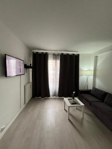 un salon avec un canapé et une table dans l'établissement Studio Élysée, à Gentilly