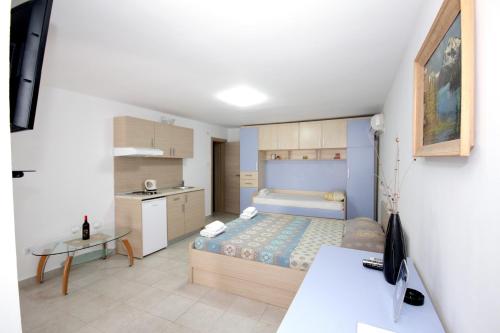 a small bedroom with a bed and a table at Apartments Pavlovic in Petrovac na Moru