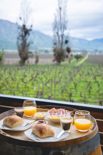 a table with a tray of food and glasses of orange juice at Apalta Lofts, disfruta frente a viñedos in Santa Cruz