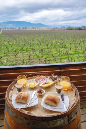 a table with plates of food on top of a barrel at Apalta Lofts, disfruta frente a viñedos in Santa Cruz