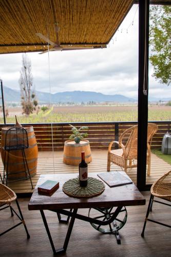 a table with a bottle of wine on a porch at Apalta Lofts, disfruta frente a viñedos in Santa Cruz