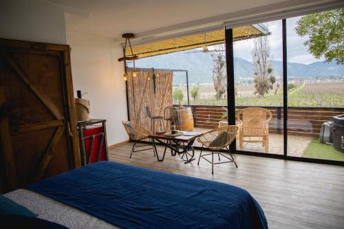 a bedroom with a bed and a table and chairs at Apalta Lofts, disfruta frente a viñedos in Santa Cruz