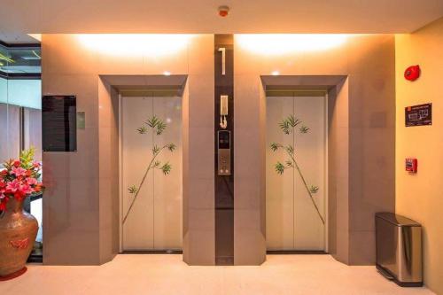 a lobby with three doors with bamboo paintings on them at At the tree by fatimah in Rawai Beach
