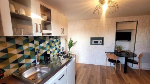 - une cuisine avec un évier et une table dans l'établissement Studio Neuf et Design, à Saint-Laurent-sur-Sèvre