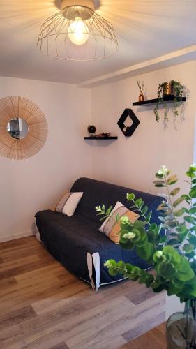 - un lit dans une chambre avec un canapé noir dans l'établissement Studio Neuf et Design, à Saint-Laurent-sur-Sèvre
