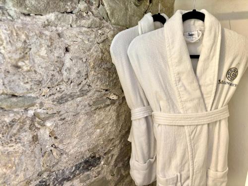 a robe hanging in front of a stone wall at Molino de los Reyes in Totolac