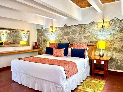a bedroom with a large bed and a stone wall at Molino de los Reyes in Totolac