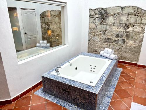 a bathroom with a bath tub with a stone wall at Molino de los Reyes in Totolac