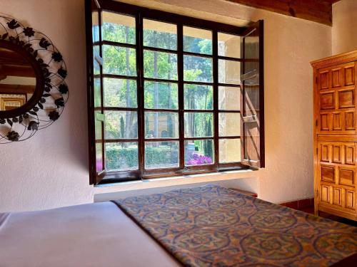 a bedroom with a bed and a large window at Molino de los Reyes in Totolac