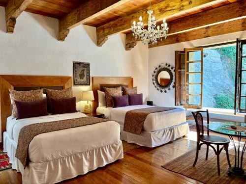 a bedroom with two beds and a chandelier at Molino de los Reyes in Totolac