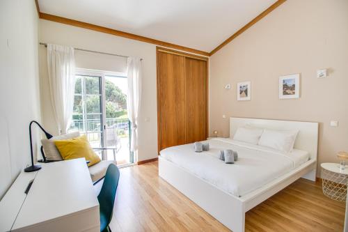 a bedroom with a white bed and a couch at Nature Escape 2BR Villa Pool Wi-Fi AC in Olhos de Água