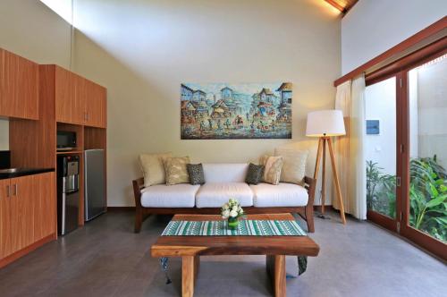 a living room with a couch and a table at Desa Di Bali Villas in Kerobokan